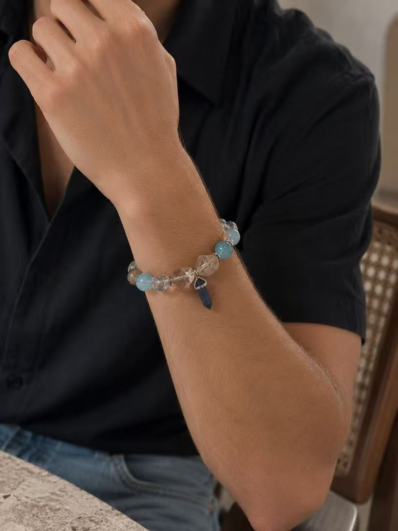 Close-up of a man's wrist wearing a luxurious Muttu crystal bracelet with a metal charm, designed for pet owners.